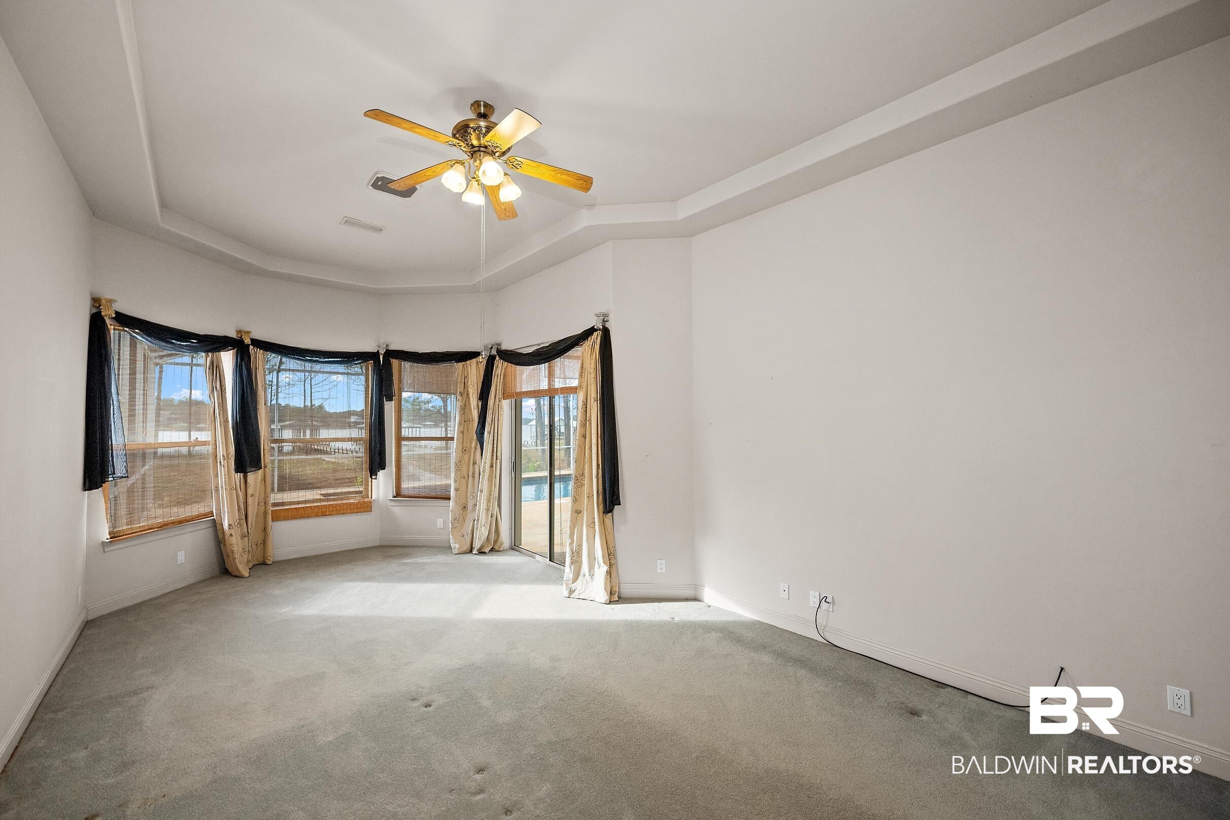 8591 Bay Harbor Road Elberta, AL 36530 - Photo 29 of 56 Carpeted spare room with a tray ceiling and ceiling fan