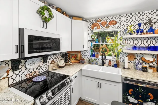 a kitchen with a refrigerator a stove a sink a dining table and chairs