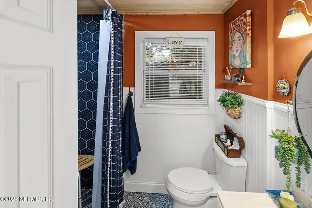 a bathroom with a toilet and a shower curtain