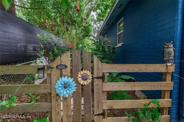 a view of a backyard with plants and a tree