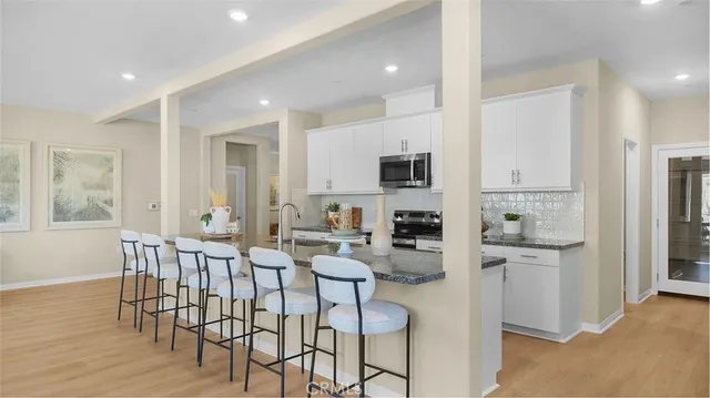a kitchen with white cabinets and stainless steel appliances
