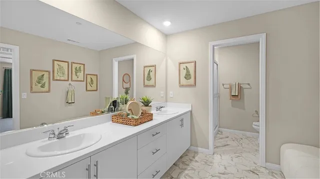 a bathroom with a sink double vanity and a toilet