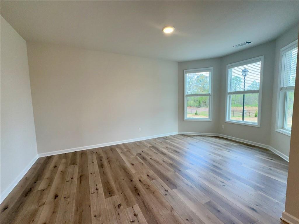 345 Rodeo Drive Auburn, GA 30011 - Photo 5 of 22 an empty room with wooden floor and windows