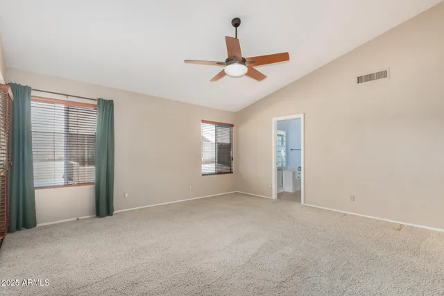 a view of empty room with window and ceiling fan