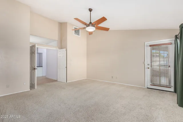 a view of an empty room with a ceiling fan