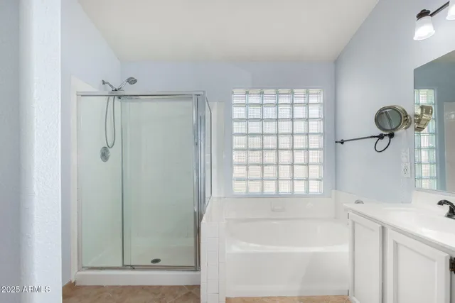 a bathroom with a bathtub a shower and a window