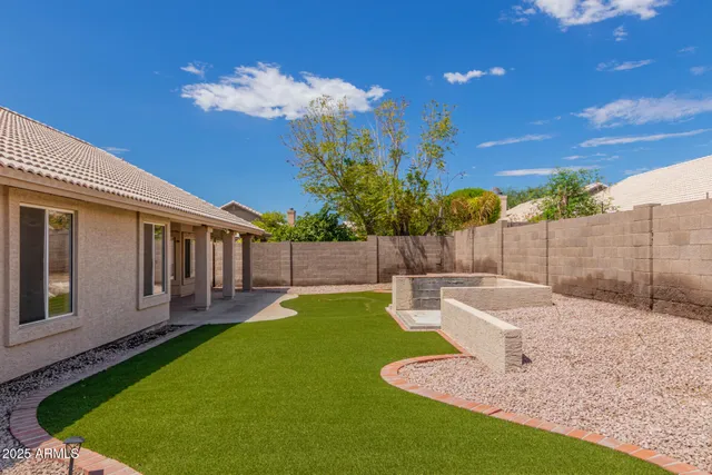 a view of a backyard with couches plants and large tree