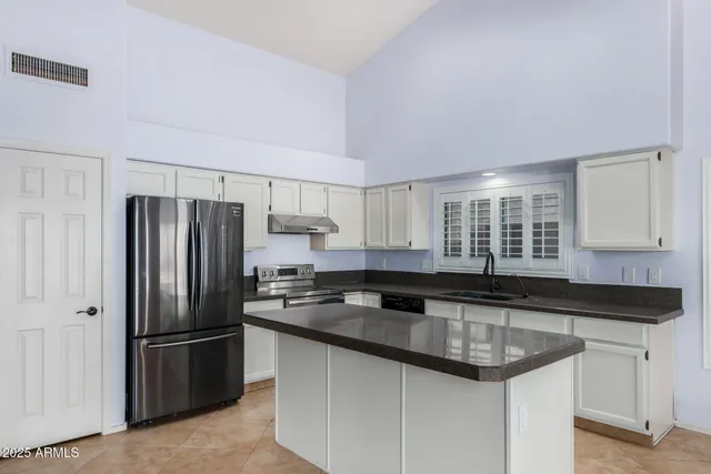 a kitchen with granite countertop a sink refrigerator and microwave