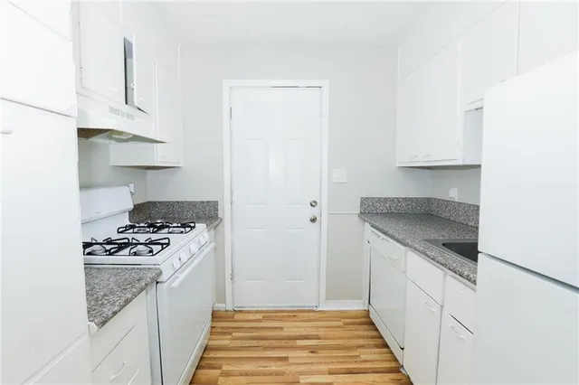 a kitchen with granite countertop a sink stove and cabinets