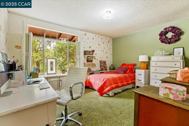 a bedroom with a bed and large windows