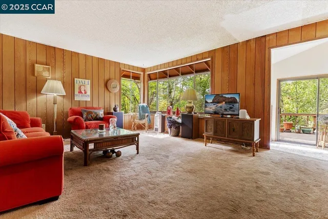 a living room with furniture a large window and a flat screen tv