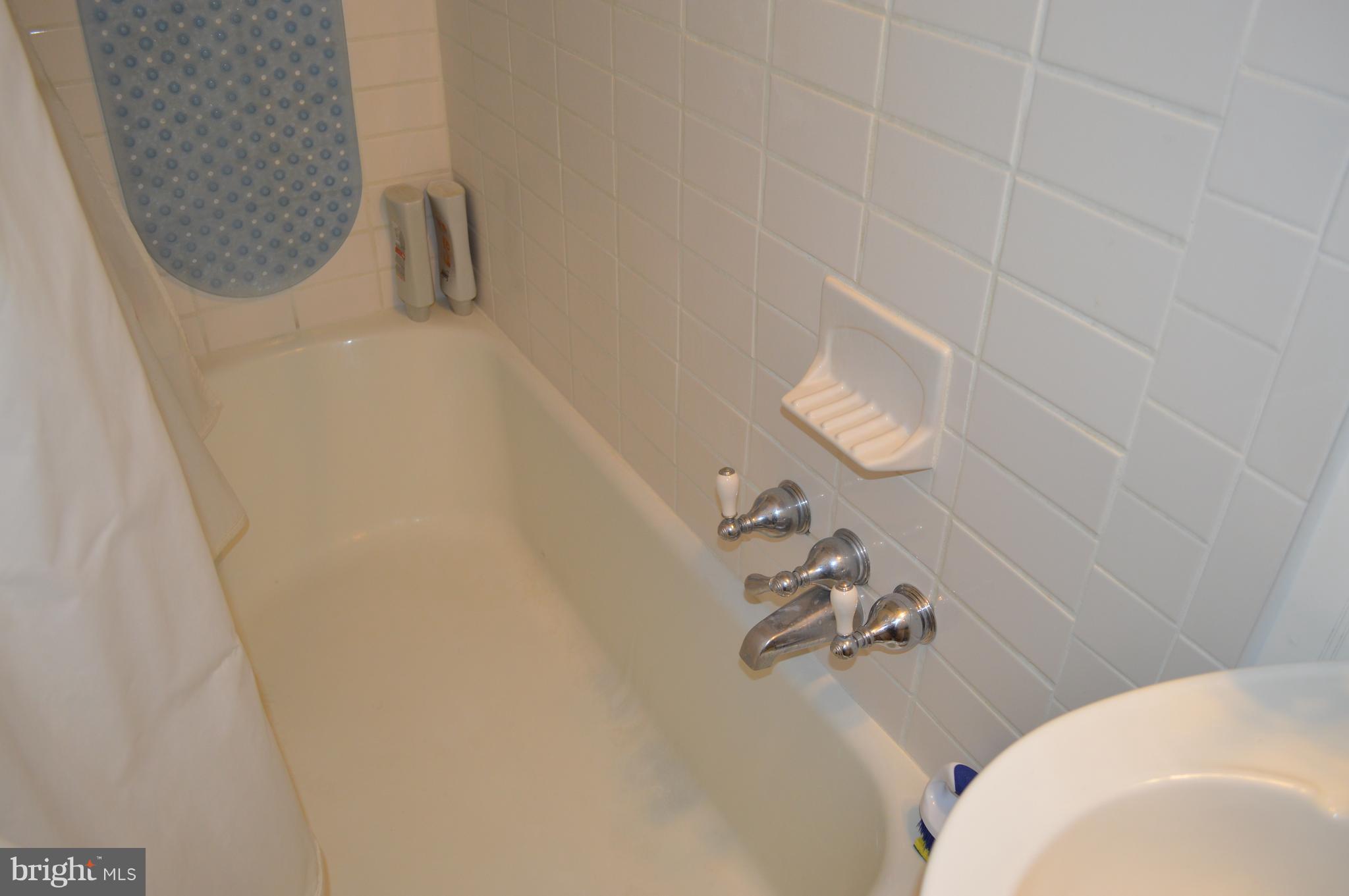 3722 Delverne Road Baltimore, MD 21218 - Photo 17 of 29 a bathroom with a white tub shower and mirror
