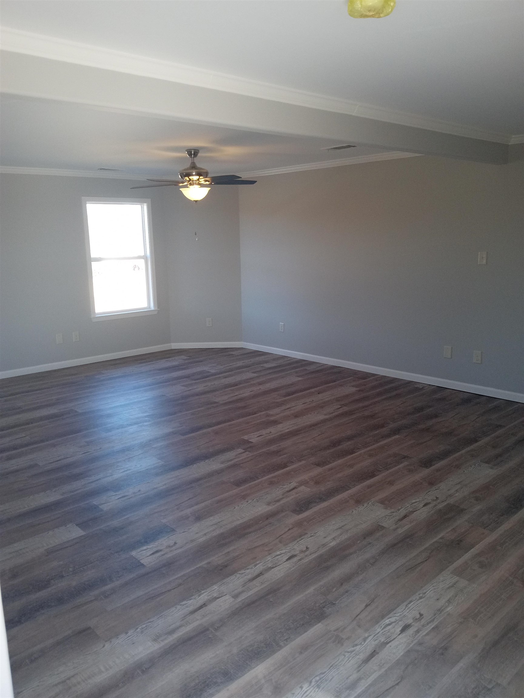 1712 Sanders Road Stanton, TN 38069 - Photo 6 of 10 Empty room featuring crown molding, ceiling fan, and dark hardwood / wood-style flooring