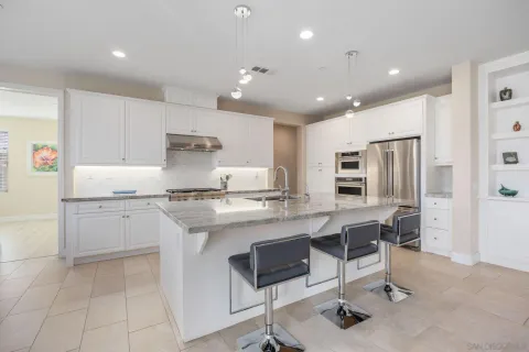 a kitchen with stainless steel appliances granite countertop a stove top oven a sink refrigerator and cabinets