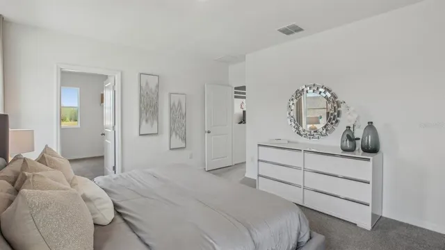 a bedroom with a bed and painting on the wall