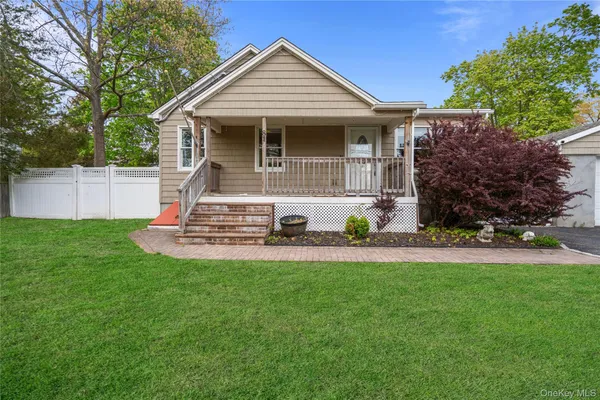 a front view of a house with a yard and trees