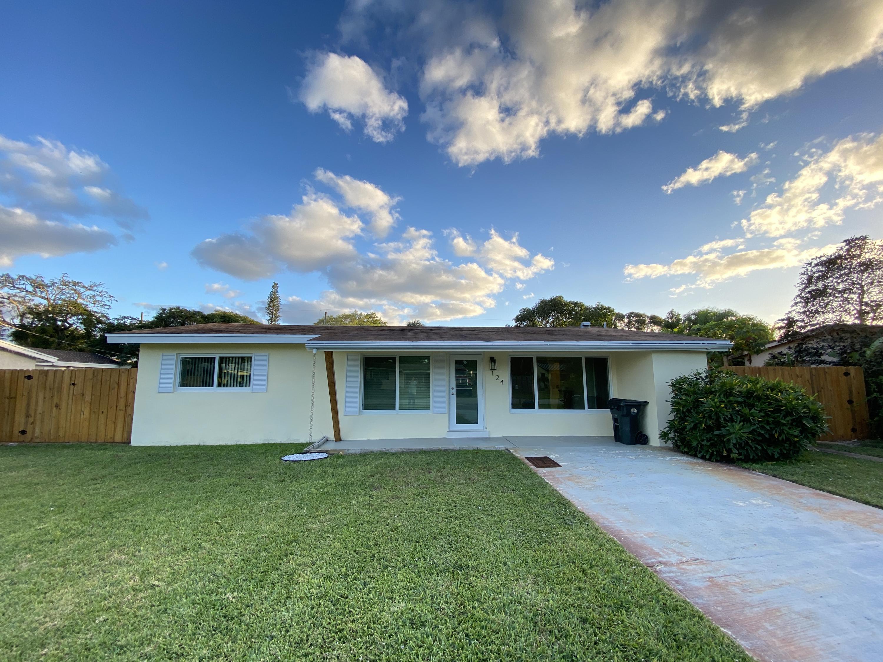 124 Northwest 9th Street Boca Raton, FL 33432 - Photo 1 of 18 a front view of a house with yard