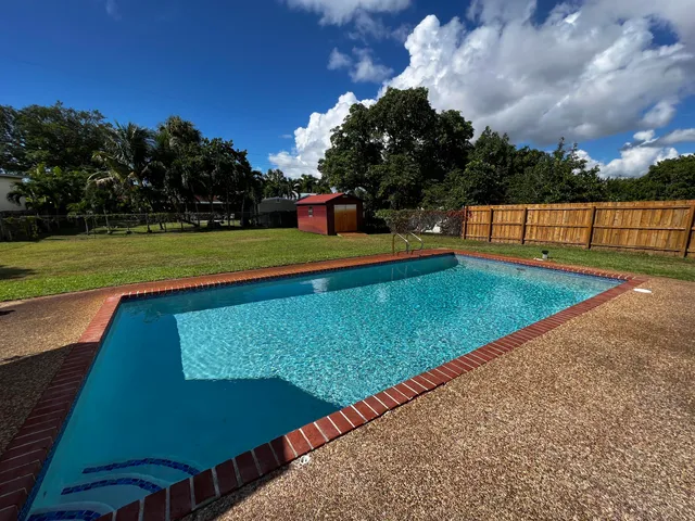 a view of a backyard with swimming pool