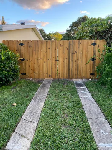 a view of a backyard with wooden fence