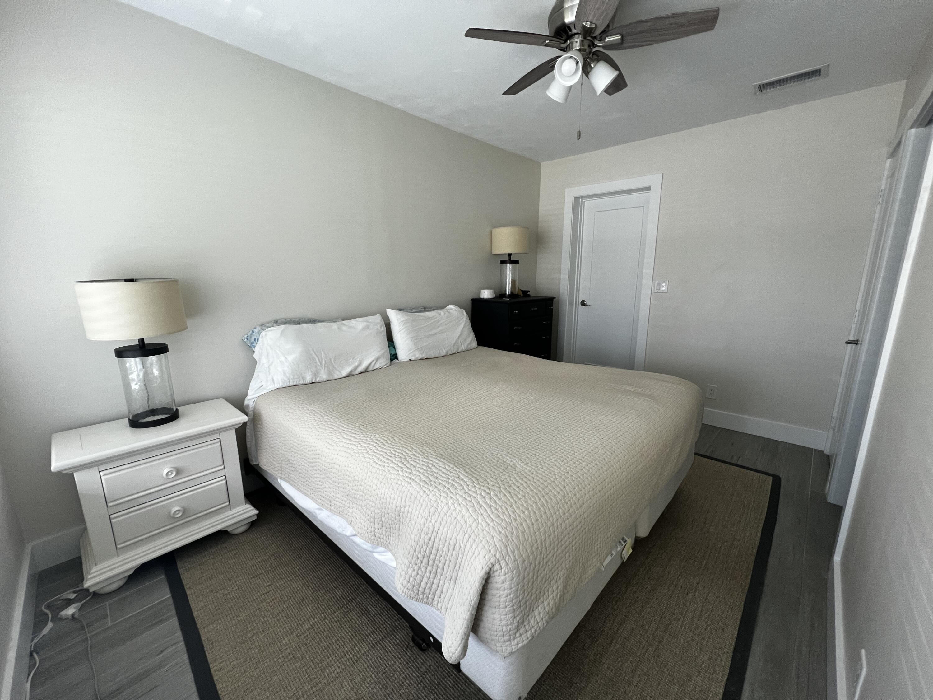 124 Northwest 9th Street Boca Raton, FL 33432 - Photo 4 of 18 a bed room with a bed and a chandelier