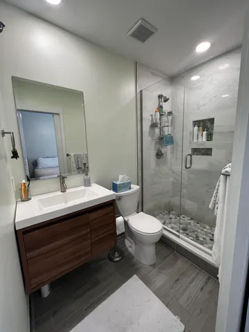 a bathroom with a sink a toilet and shower