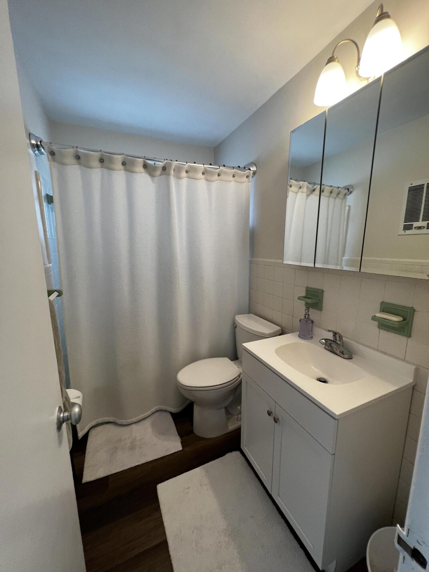 124 Northwest 9th Street Boca Raton, FL 33432 - Photo 8 of 18 a bathroom with a toilet sink and mirror