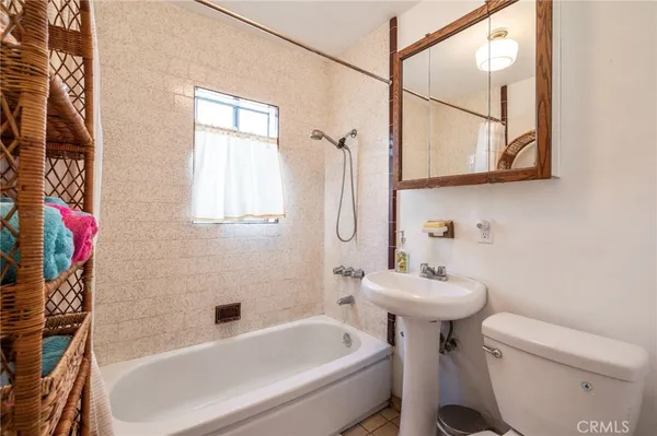 a bedroom with a bed and a flat tv screen on dresser