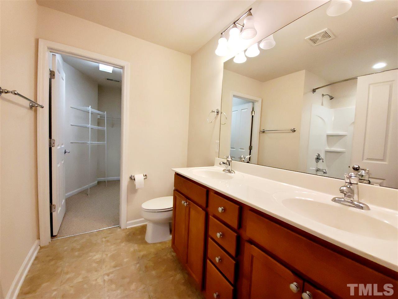 8332 Saltwood Place Raleigh, NC 27617 - Photo 5 of 16 a spacious bathroom with a double vanity sink toilet and shower