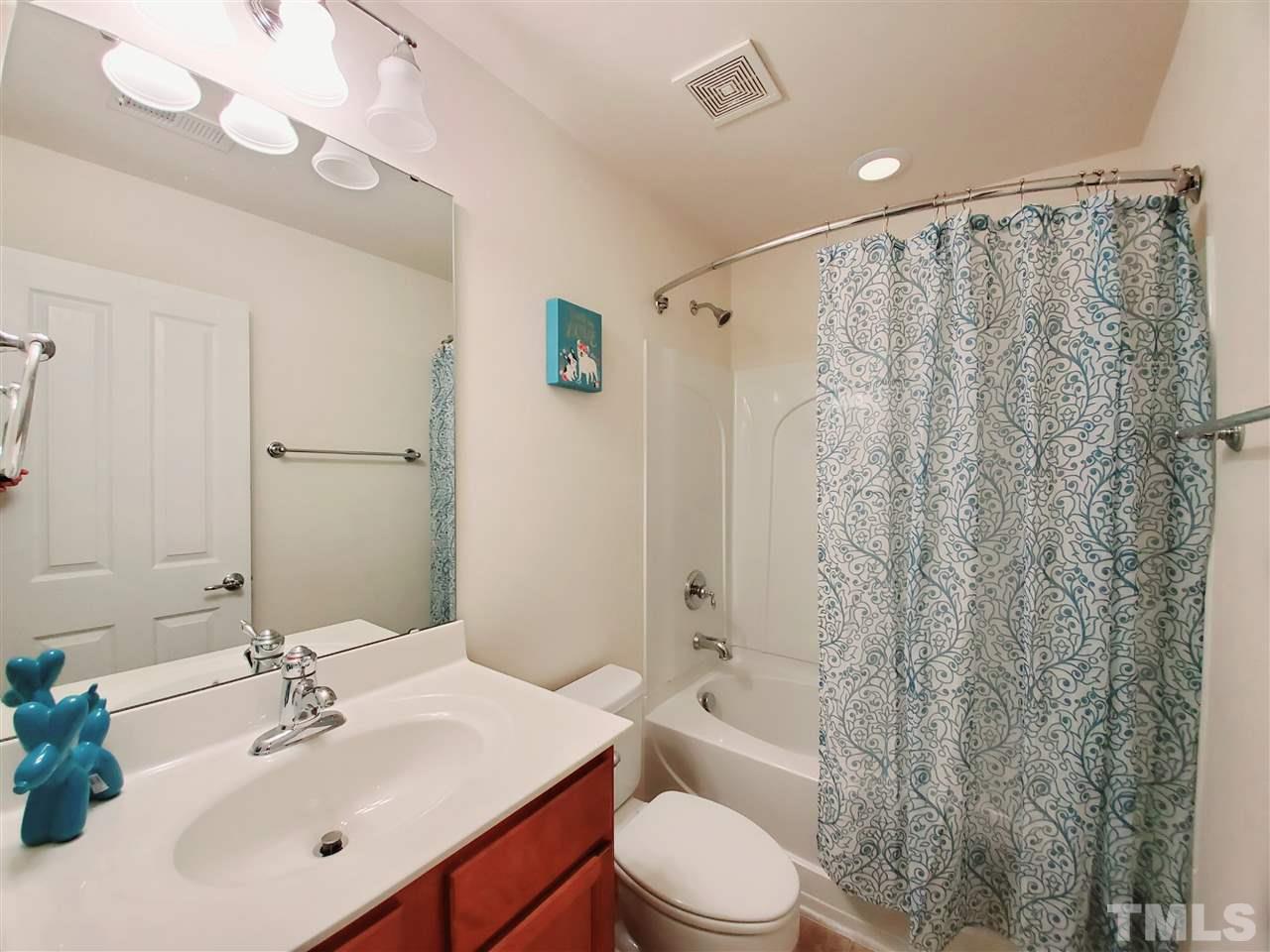 8332 Saltwood Place Raleigh, NC 27617 - Photo 8 of 16 a bathroom with a sink a toilet a mirror a vanity and shower