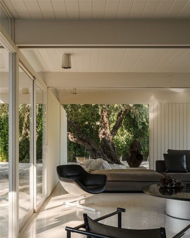 a living room filled with furniture and a floor to ceiling window