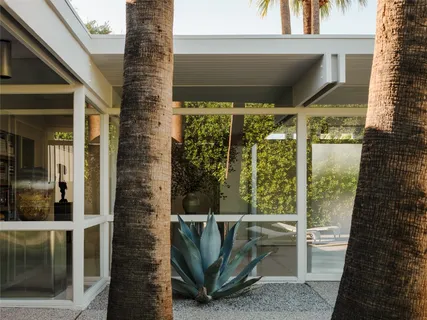 a living room with couches a coffee table and a large window with outer view