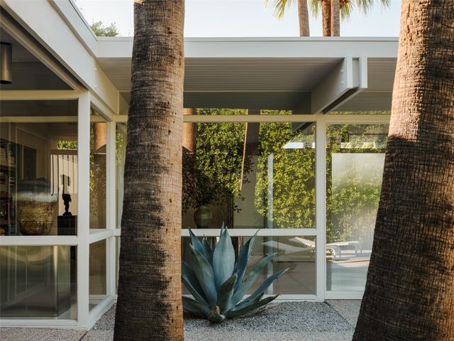 a living room with couches a coffee table and a large window with outer view