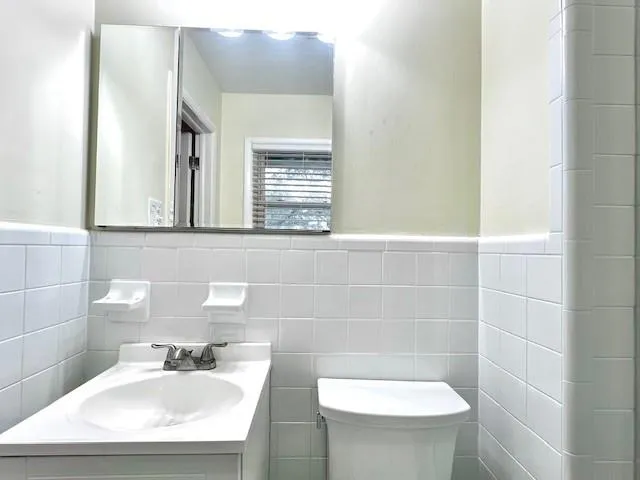 a bathroom with a sink a toilet and a mirror
