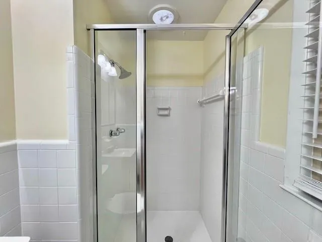 a bathroom with a glass shower door and a shower
