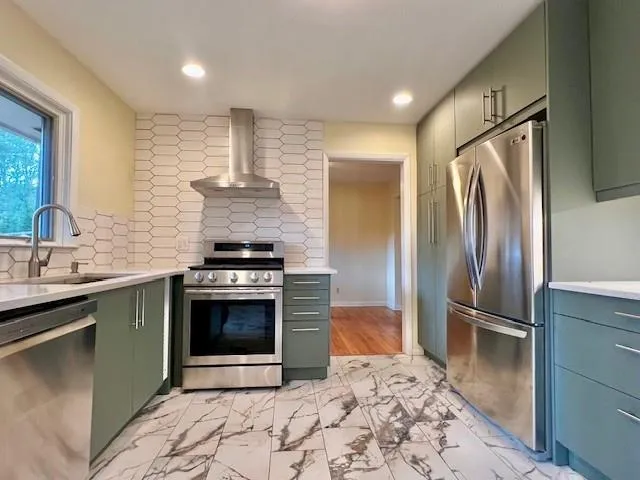 a kitchen with stainless steel appliances granite countertop a refrigerator and a sink