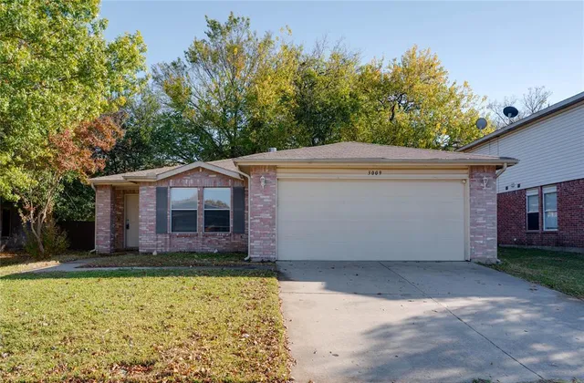 a front view of house with yard and trees in the background