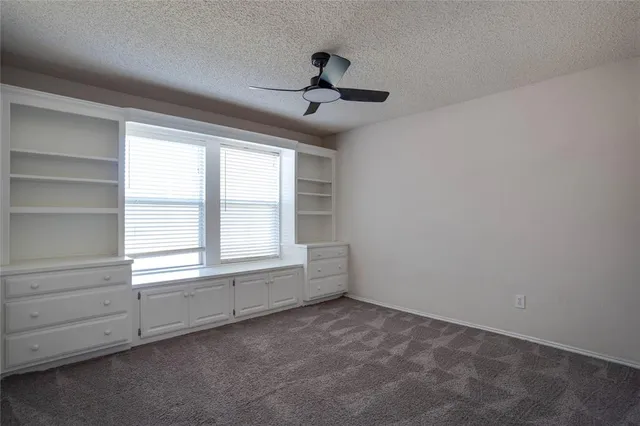 a view of a livingroom with a ceiling fan and window