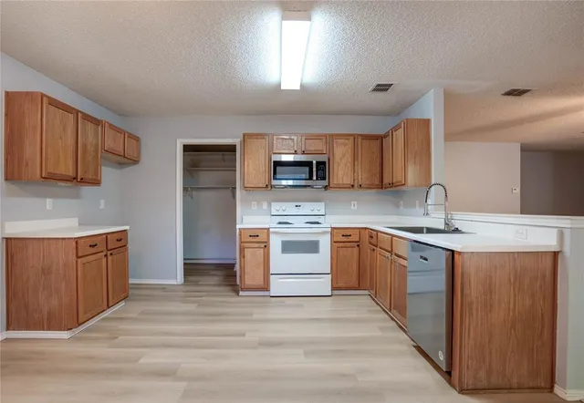 a kitchen with stainless steel appliances granite countertop a sink stove and microwave