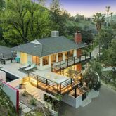 an aerial view of a house with swimming pool and trees