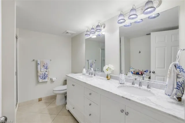 a bathroom with a double vanity sink mirror and toilet