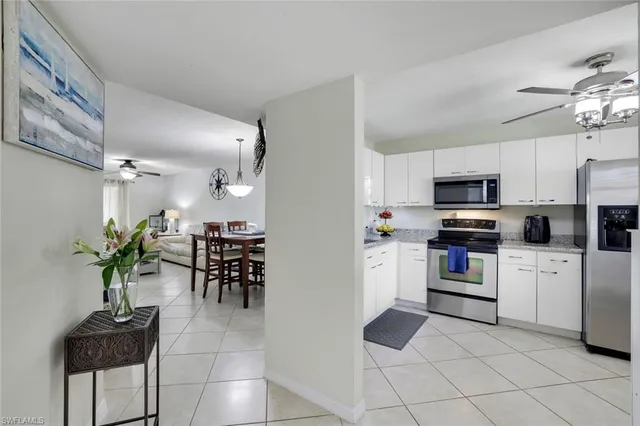 a kitchen with granite countertop stainless steel appliances a stove top oven a sink a dining table and chairs