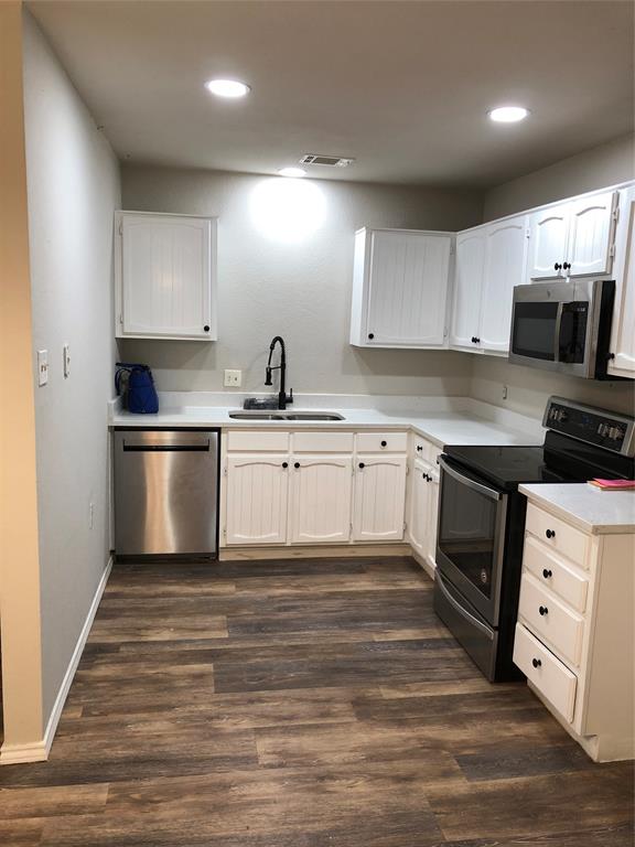 a kitchen with stainless steel appliances a stove sink and cabinets