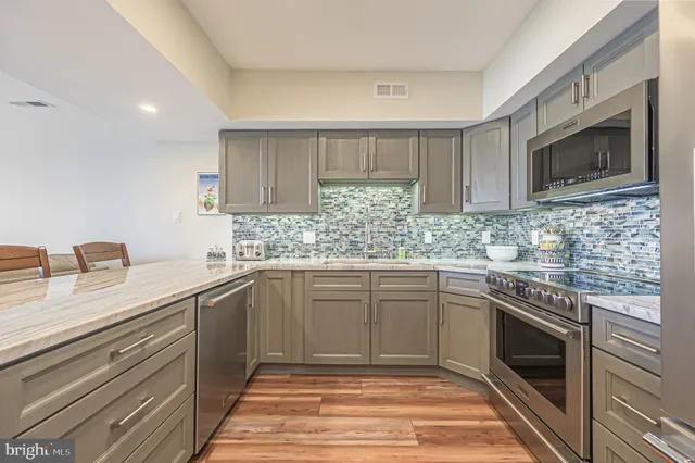 a kitchen with granite countertop cabinets stainless steel appliances and a sink
