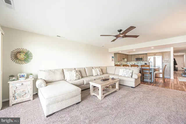 a living room with furniture kitchen view and a window