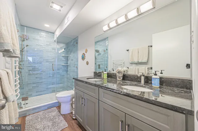 a bathroom with a granite countertop toilet sink and mirror