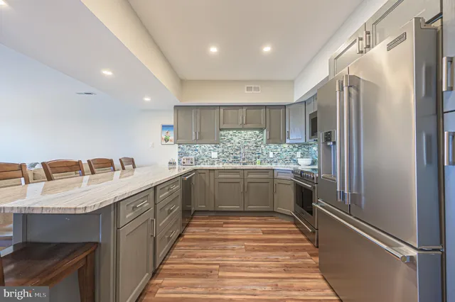 a kitchen with stainless steel appliances granite countertop a sink refrigerator and cabinets