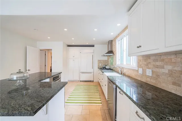 a large kitchen with stainless steel appliances granite countertop a sink stove and cabinets