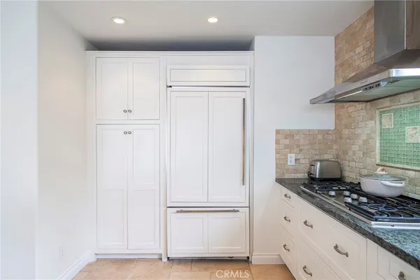 a kitchen with white cabinets and white appliances