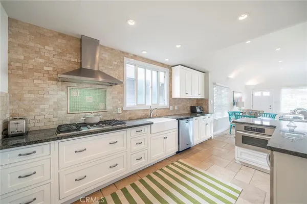 a large kitchen with stainless steel appliances kitchen island granite countertop a sink and cabinets