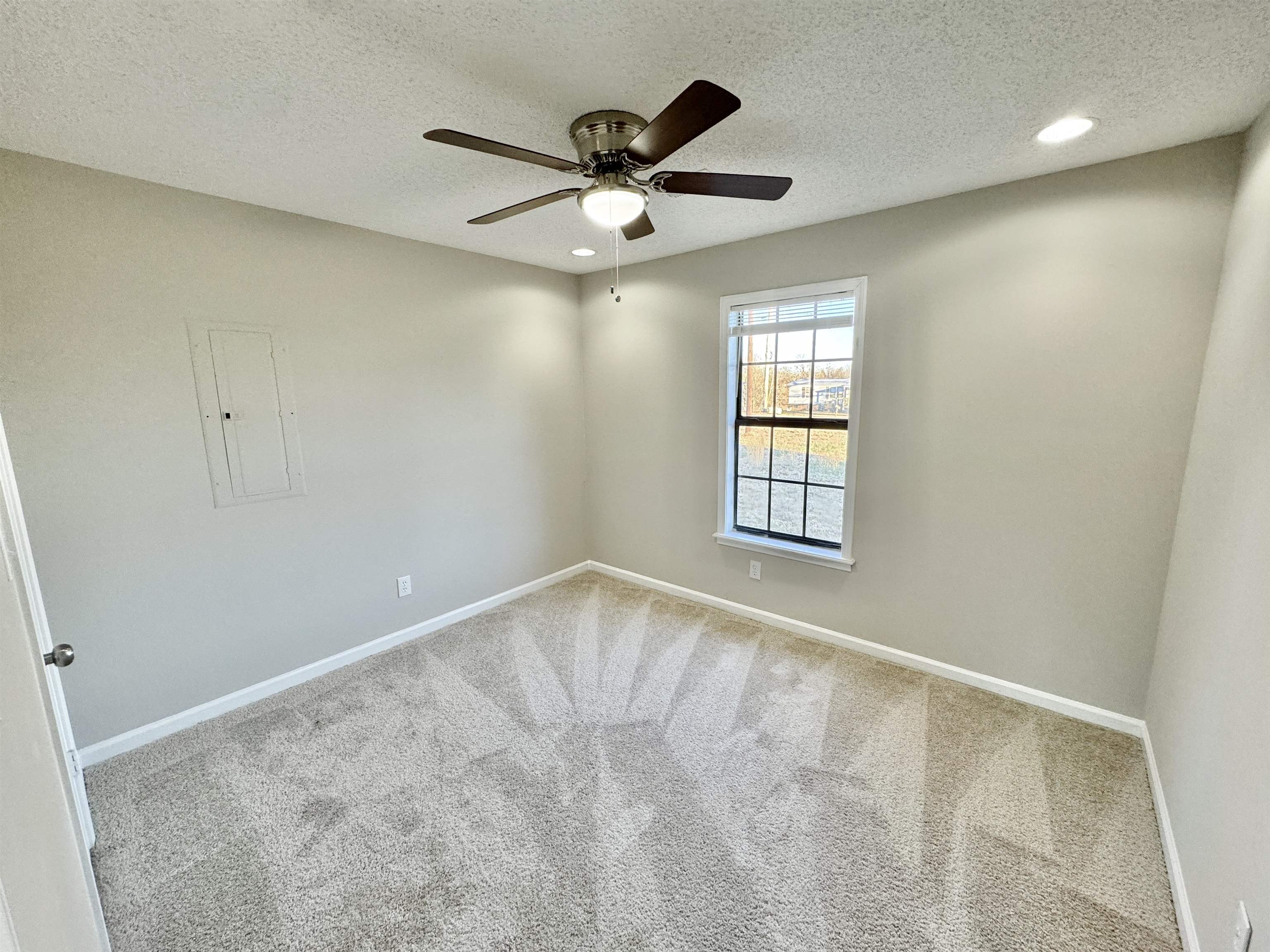 775 Portersville Road Atoka, TN 38004 - Photo 20 of 37 Carpeted empty room featuring ceiling fan, electric panel, and a textured ceiling